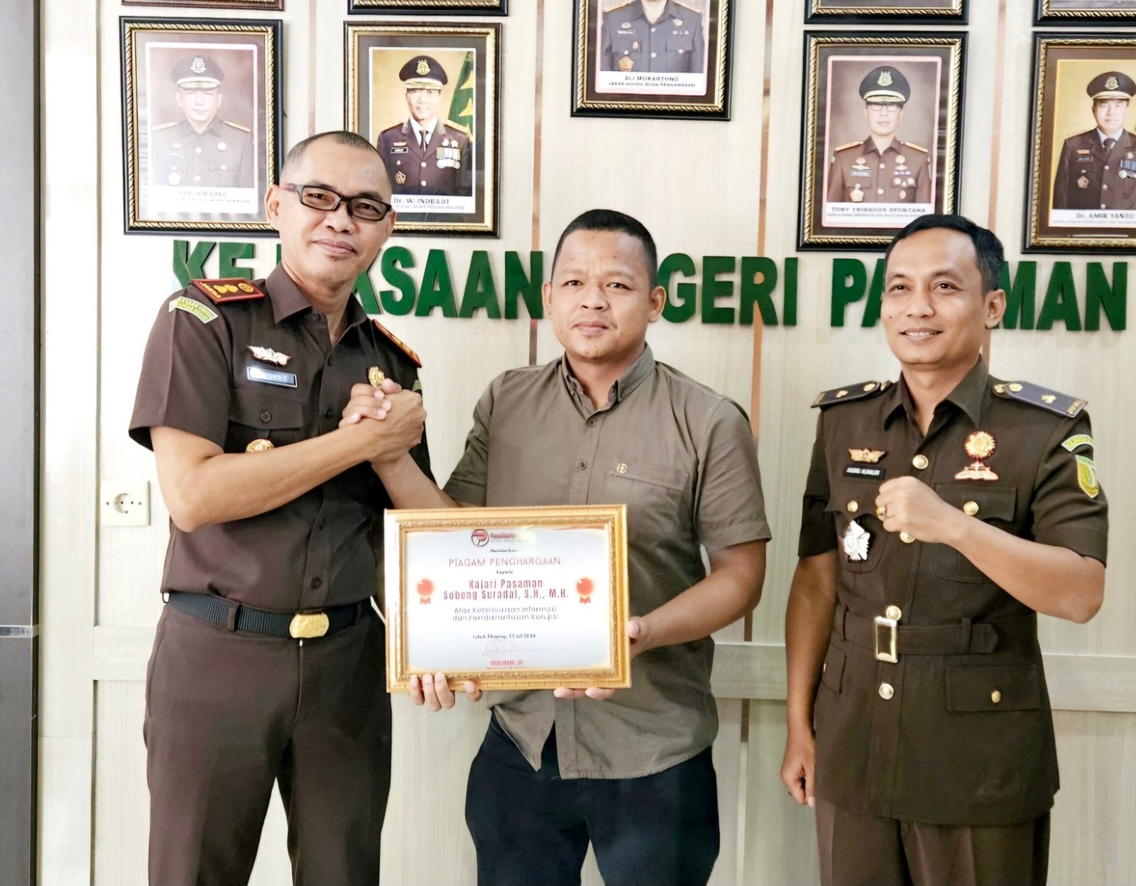 Pemimpin Redaksi PenaHarian.com, Darlinsah, SH memberikan piagam penghargaan kepada Kajari Pasaman Sobeng Suradal, SH., M.H. didampingi Kasi Pidsus Agung Malik Rahman Hakim di ruang kerja Kajari pada hari Rabu, 24 Juli 2024.
