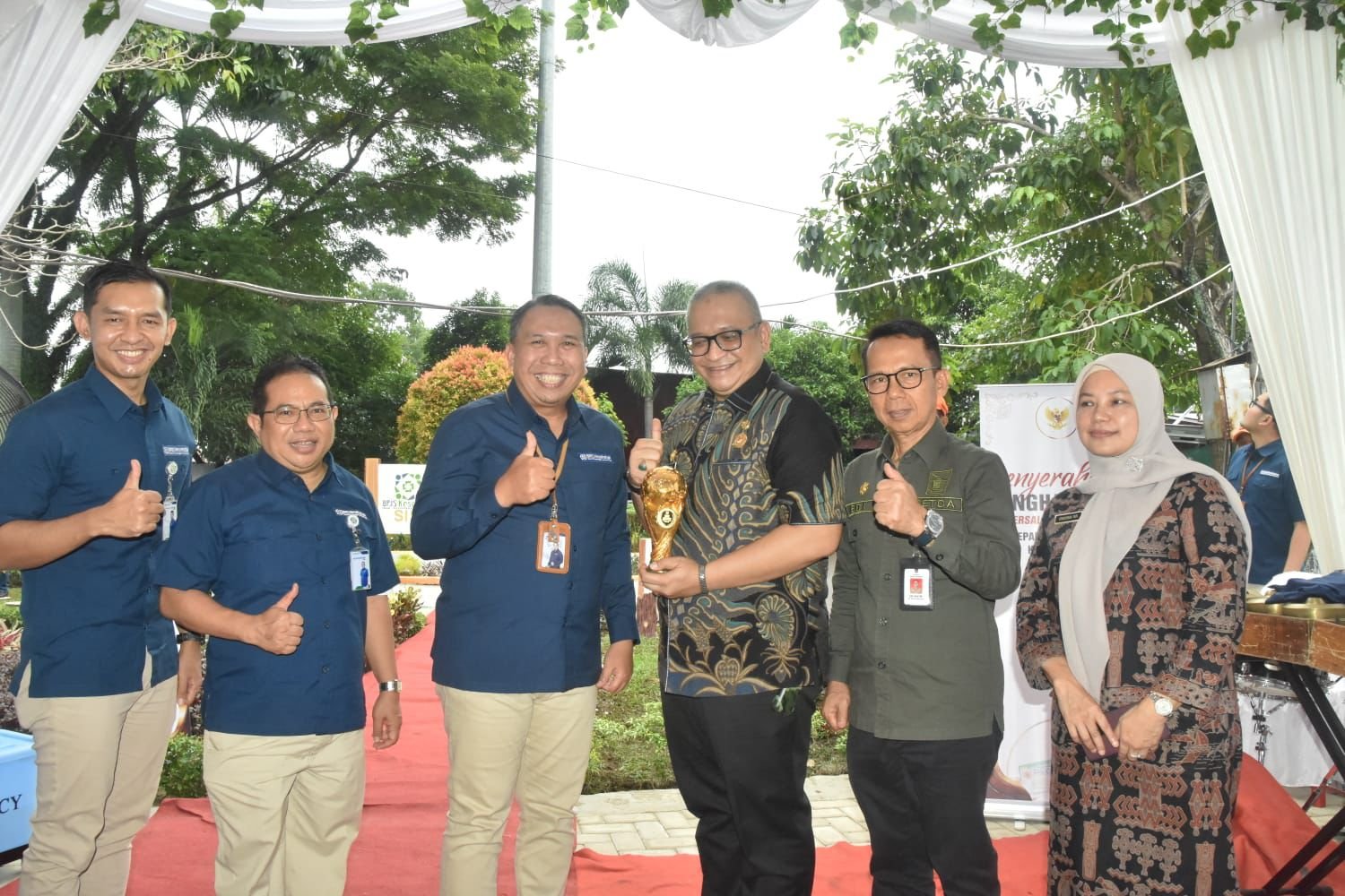 Penjabat (Pj) Wali Kota Padang, Andree Algamar, menerima piagam penghargaan Universal Health Coverage (UHC) Award Kategori Madya dari Direktur SDM dan Umum BPJS Kesehatan, Andi Afdal, di Taman Sisingamangaraja, Padang, pada Kamis (22/8/2024) pagi