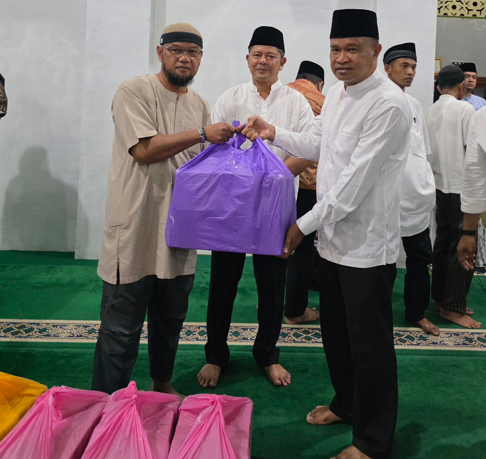 Khairuddin Simanjuntak didampangi Bupati Pasaman, Welly Suheri menyerahkan bantuan paket sembako dari anggota DPR RI Andre Rosiade kepada pengurus Masjid untuk anak yatim saat Safari Ramadan di Masjid Nurul Huda Tampang, Lubuk Sikaping, Kabupaten Pasaman, Minggu (22/2/2026).